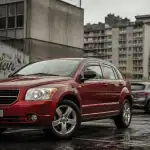 chrysler dodge caliber rouge sur parking urbain